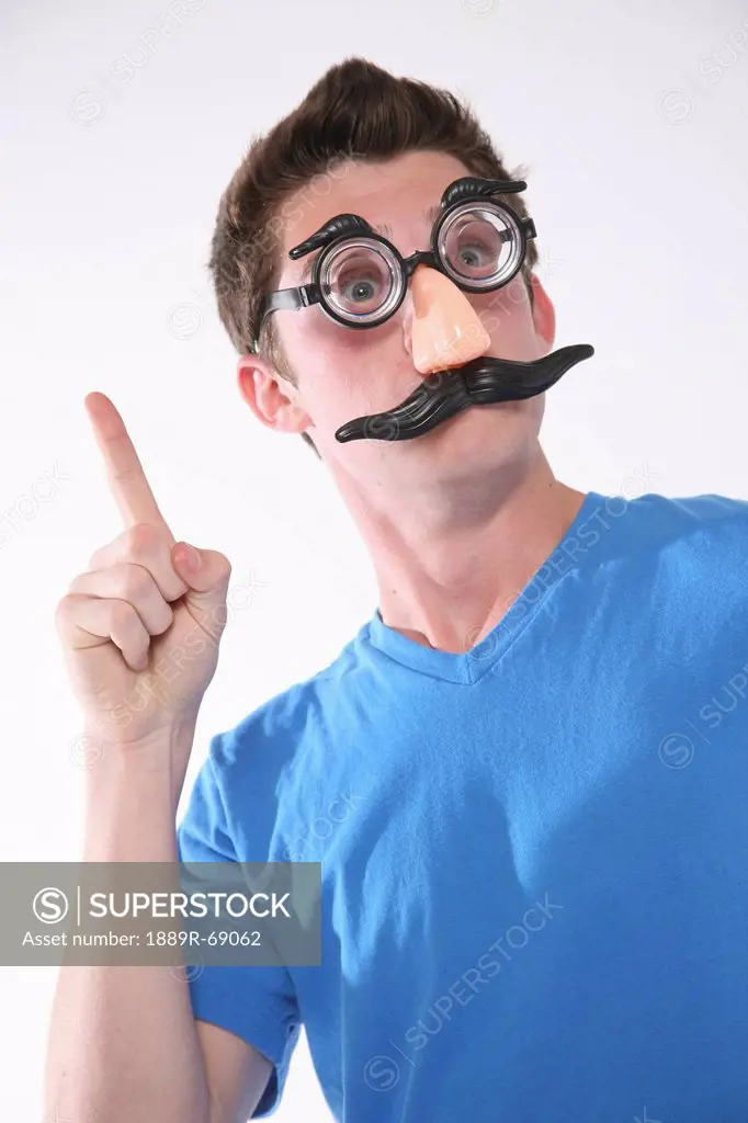 a teenage boy wearing a groucho marx mask and holding a finger up, troutdale oregon united states of america
