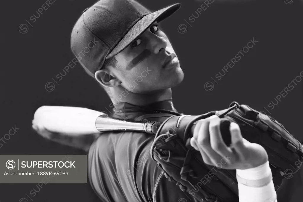 a teenage boy holding a baseball mitt and bat and wearing a cap, troutdale oregon united states of america