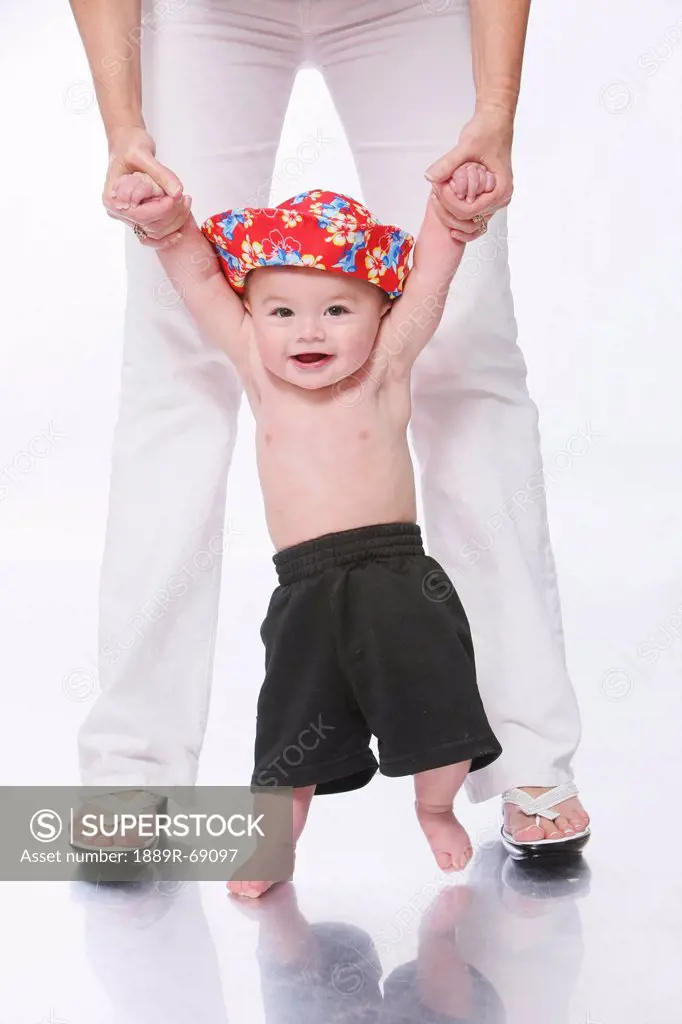 a shirtless baby boy standing between mother´s legs, troutdale oregon united states of america