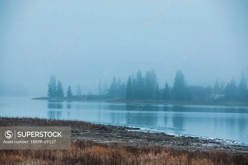 islands in the evening fog at astotin lake, edmonton alberta canada