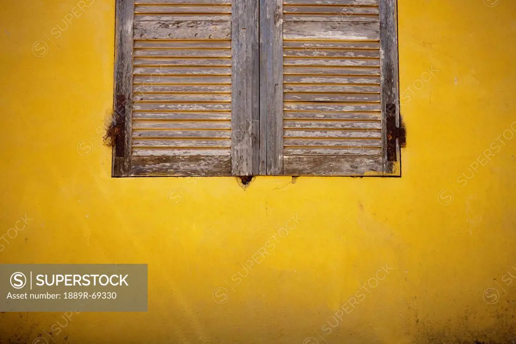 wooden shutters on a yellow wall, dakar senegal