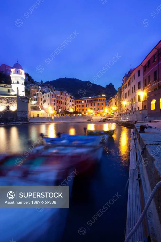 boats moored by buildings along the waterfront at night, vernazza liguria italy
