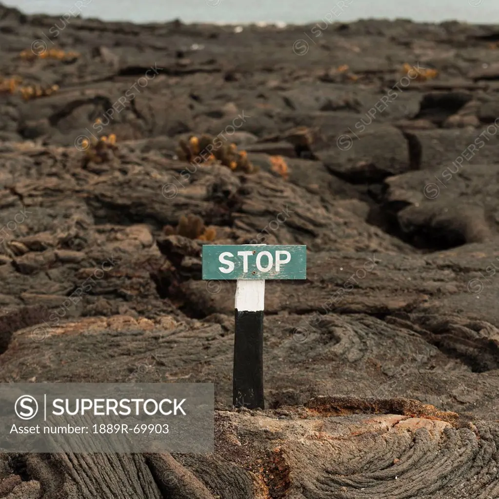 a stop sign posted on molten rock, galapagos, equador