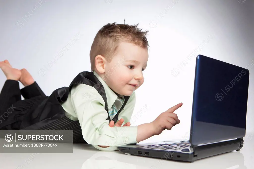 a young boy uses a laptop computer, edmonton alberta canada