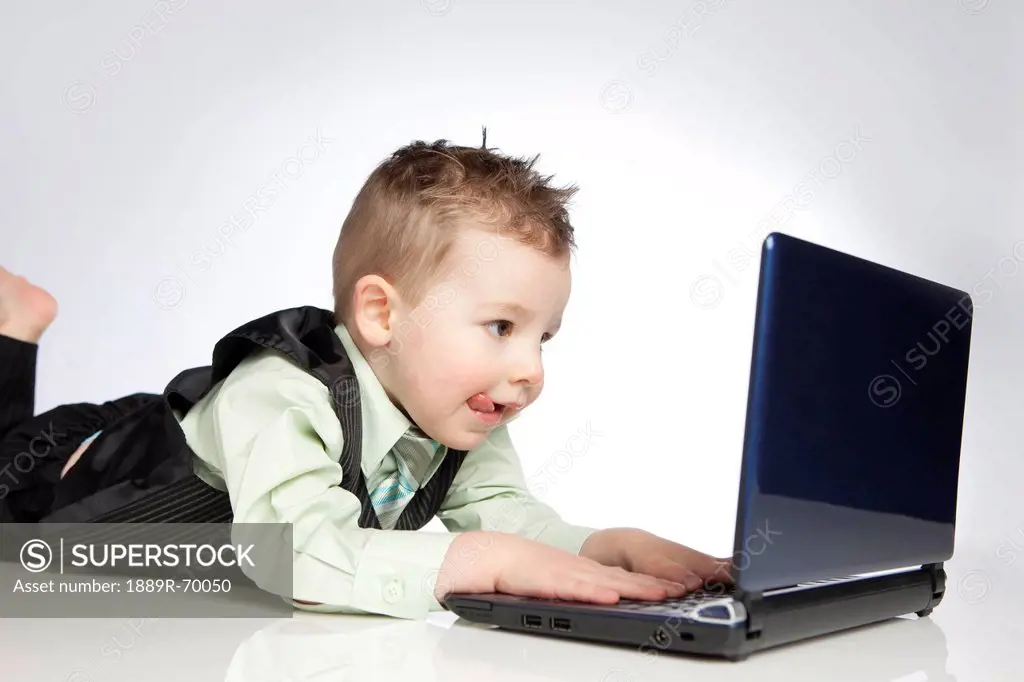 a young boy uses a laptop computer, edmonton alberta canada