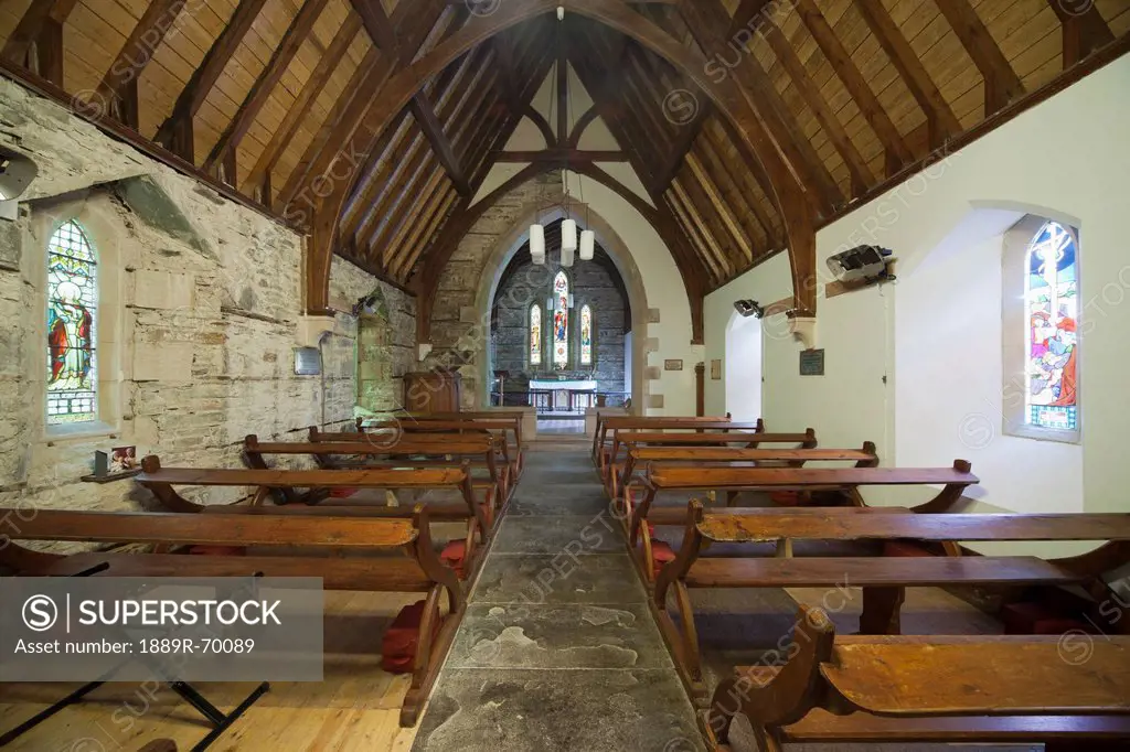 wooden benches and stained glass windows inside a church, ardnamurchan argyl scotland