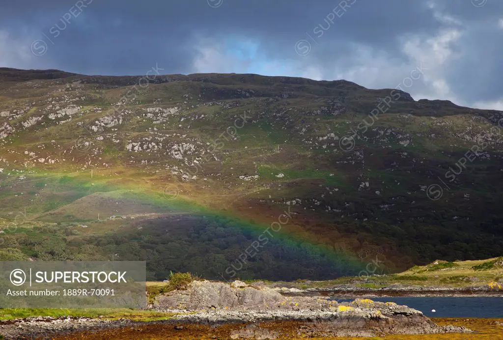 a rainbow reflected on a hill, highlands scotland