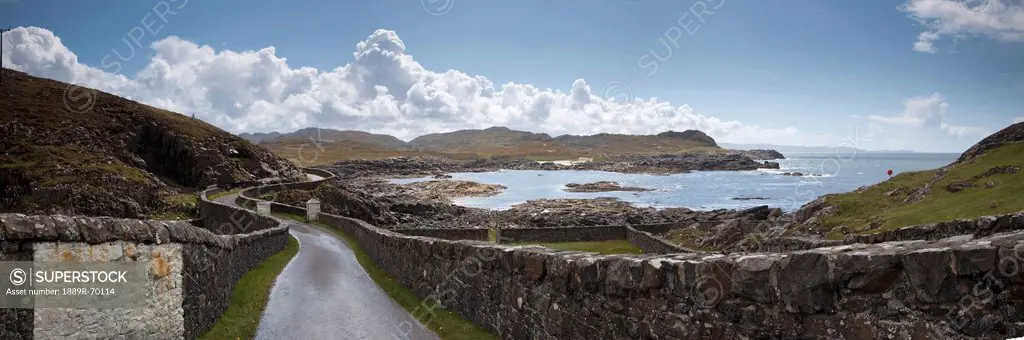 a road lined with a stone fence along the coast, ardnamurchan argyl scotland