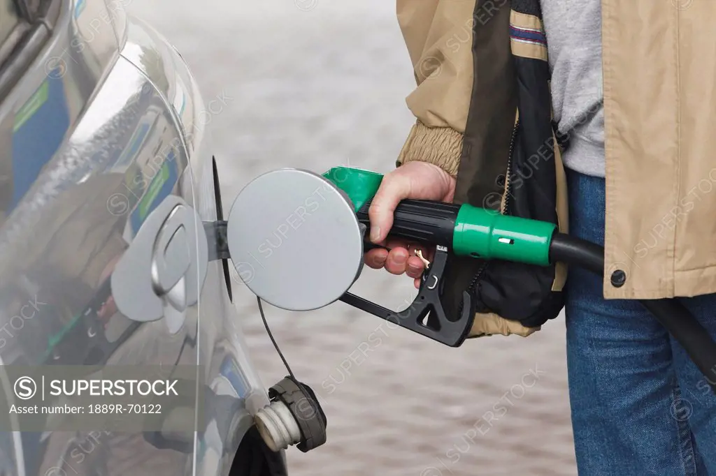 man pumping petrol into car, dunmanway county cork ireland