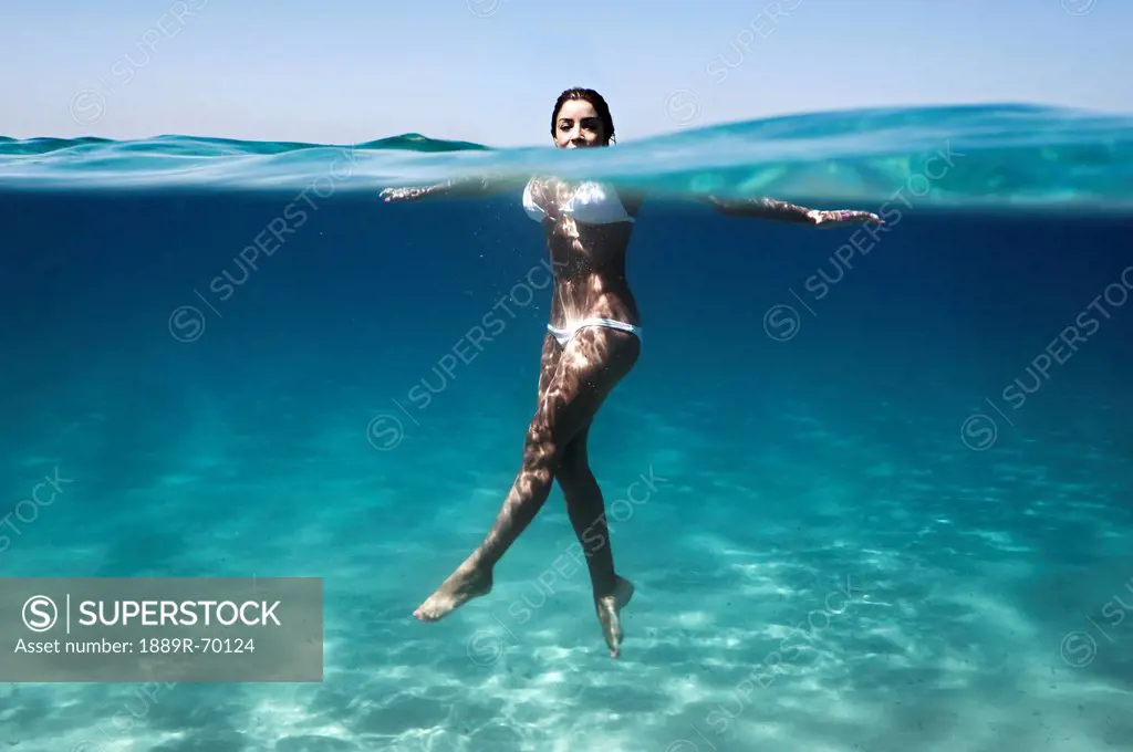 a woman´s body immersed in water wearing a two piece bathing suit, tarifa cadiz andalusia spain