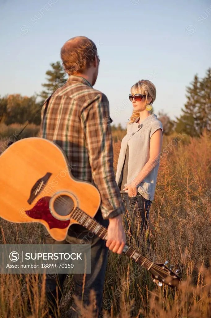 a couple standing in a field with a guitar, edmonton alberta canada