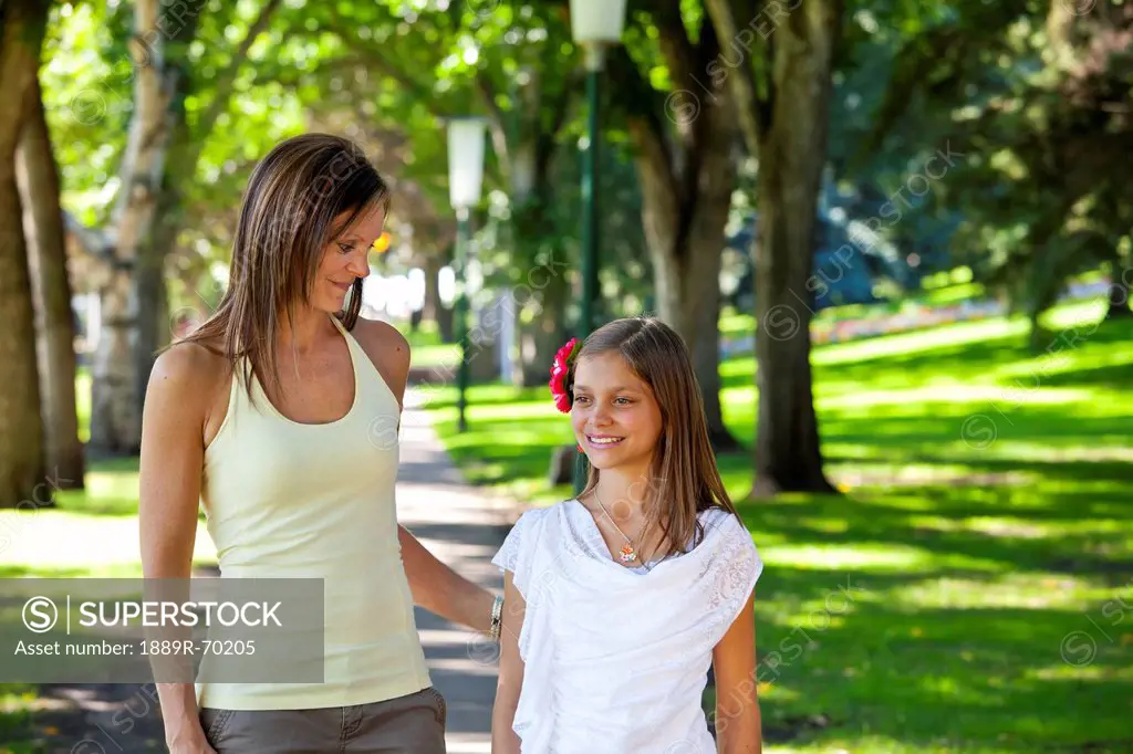 mother and daughter walking together in the park, edmonton alberta canada