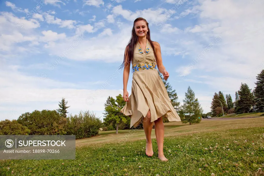 a young woman dancing in a park with a flowing dress, edmonton alberta canada