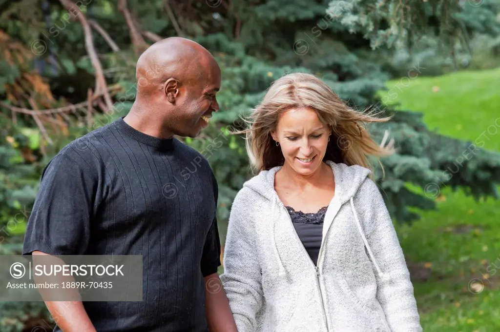interracial married couple walking in a park in autumn, edmonton alberta canada