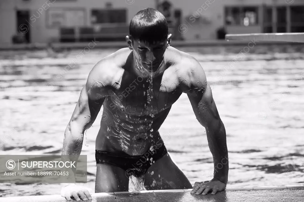 diver pulling himself out of the pool with water dripping off him, portland oregon united states of america