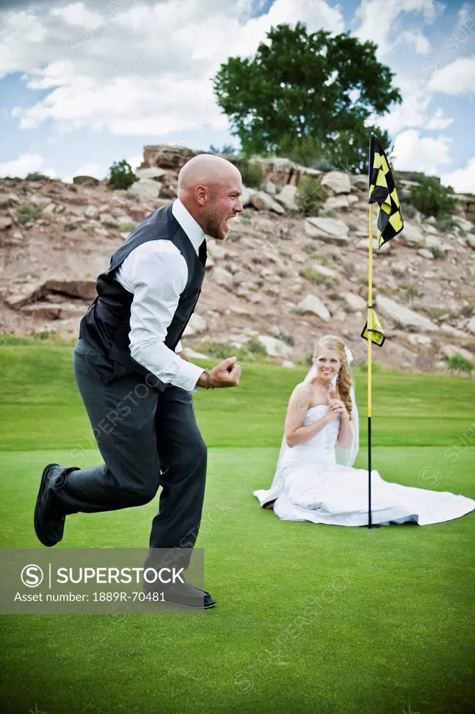 bride and groom joke around on golf course, grand junction colorado united states of america