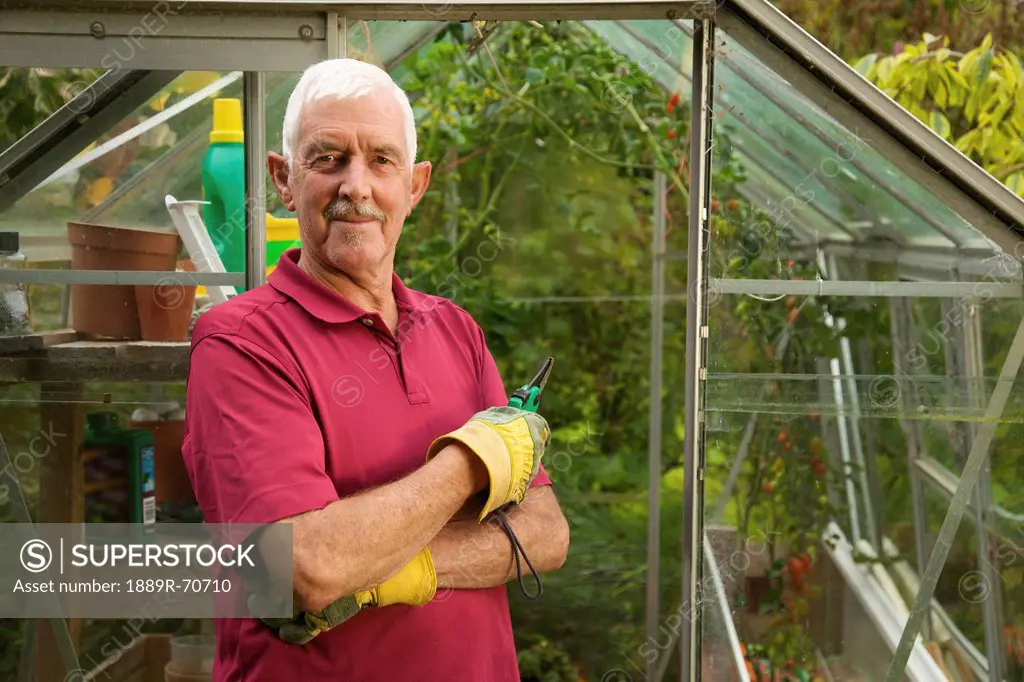a man standing outside a greenhouse wearing gardening gloves, naas, county kildare, ireland
