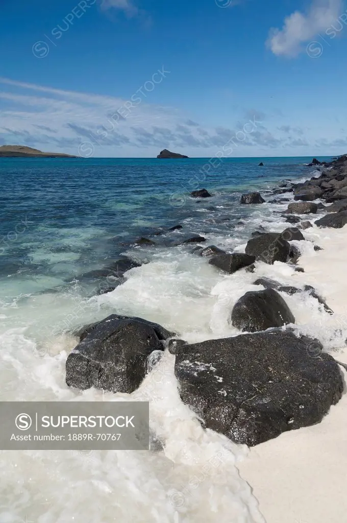 water rushing up onto the white sand in gardner bay of espanola island, galapagos, equador