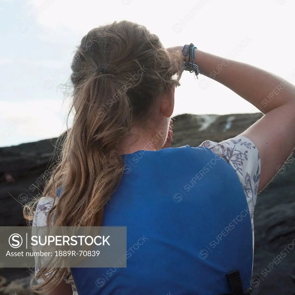 a young woman looks into the distance, galapagos equador