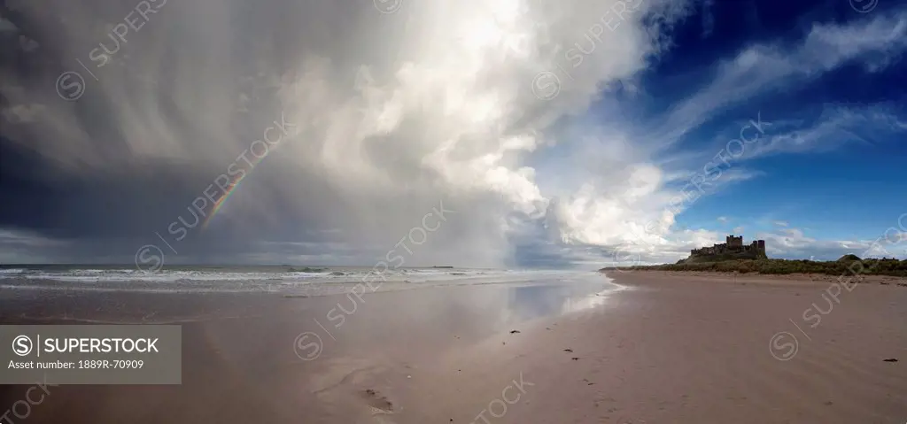 clouds reflected in the shallow water on a beach, northumberland england