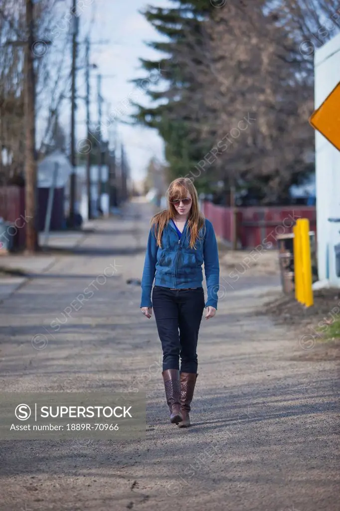 a young woman walking alone down an alley, edmonton alberta canada