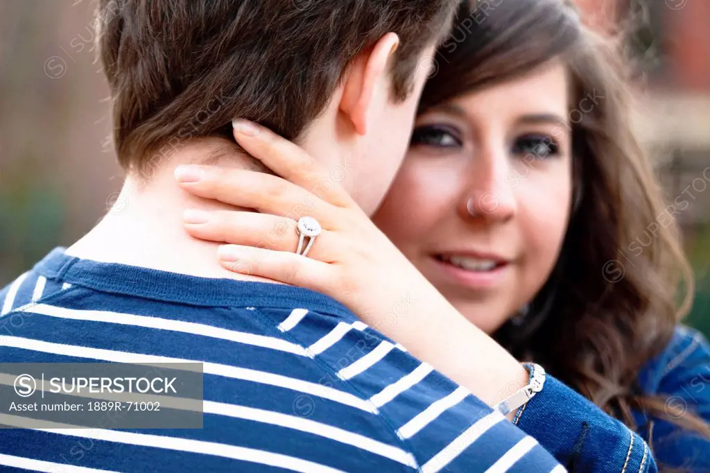 a young woman wearing a diamond ring embraces her fiance, bellingham washington united states of america