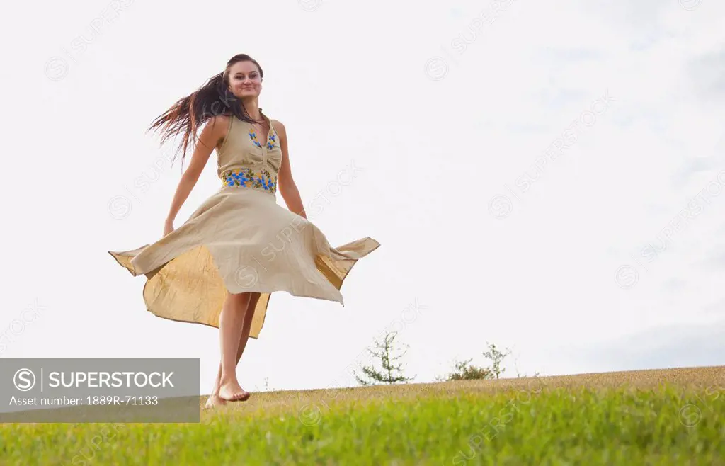 young woman dancing in the park with a flowing dress, edmonton alberta canada