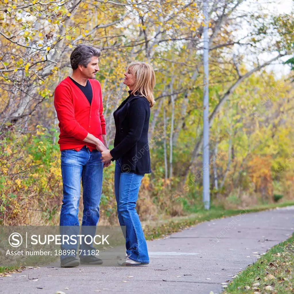 husband and wife walking in the park during autumn, st. albert alberta canada