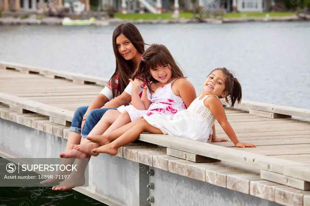 three sisters on a pier at a residential lake community, edmonton alberta canada