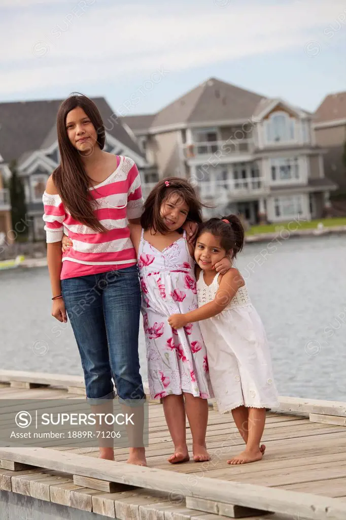 three sisters on a pier in a residential lake area, edmonton alberta canada