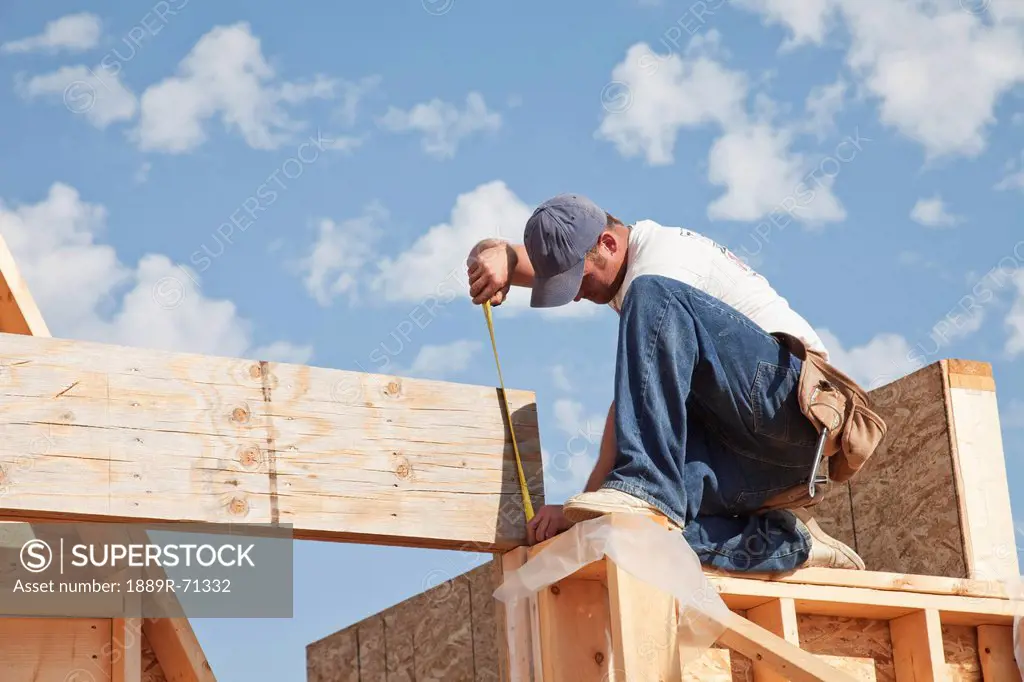tradesman working on framing for new home construction, st. albert alberta canada