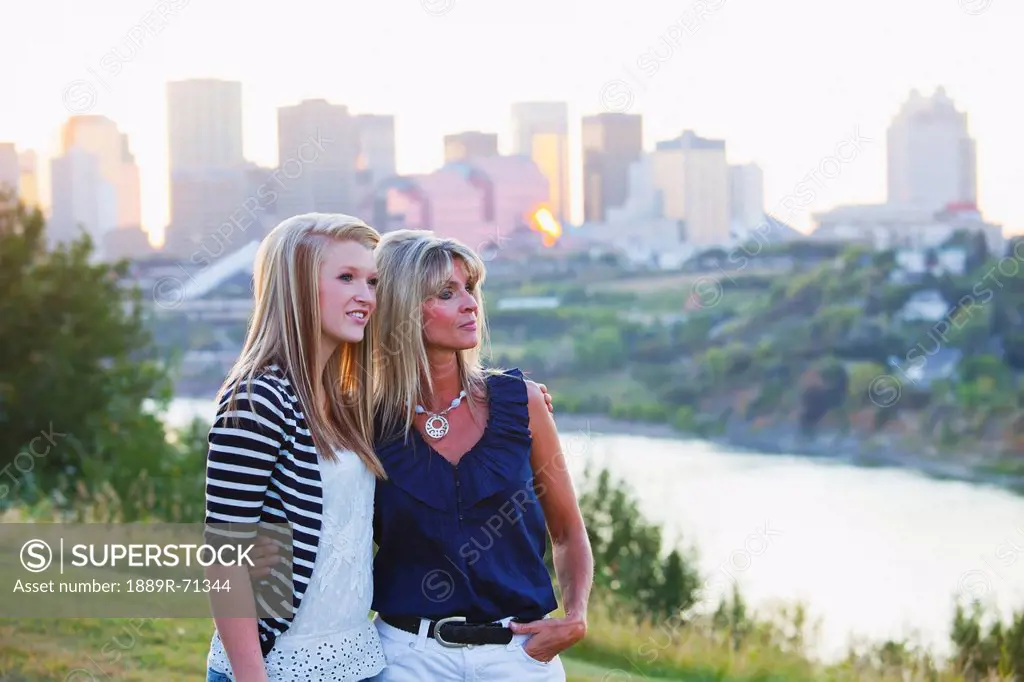 mother and daughter in a park together with the city skyline in the background, edmonton alberta canada