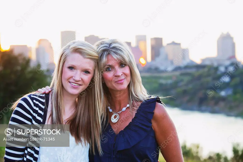 mother and daughter in a park together with the city skyline in the background, edmonton alberta canada