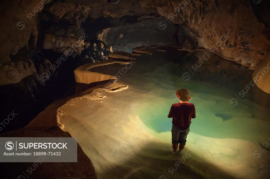 a filipino tour guide holds a lantern inside sumaging cave or big cave, sagada luzon philippines
