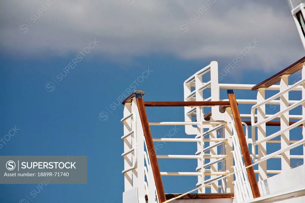 a white railing on a staircase with a blue sky and clouds in the background, bay of biscay, france
