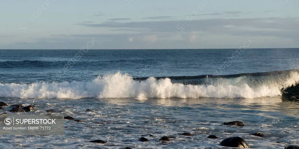 waves crashing into the shore, galapagos, equador