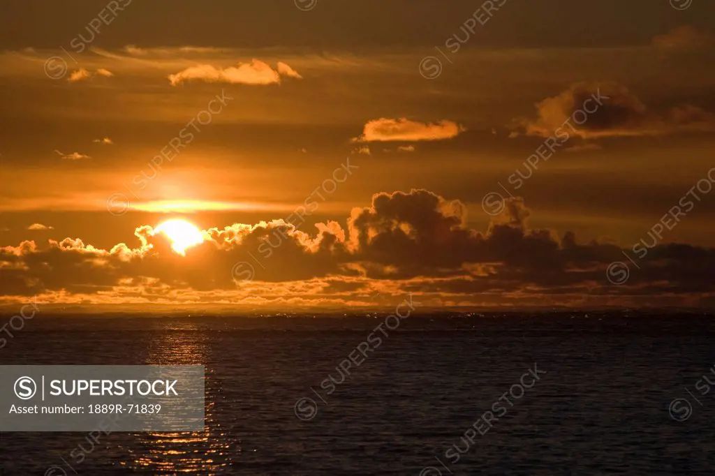 sun setting on the ocean with the sunlight reflecting on the water, lincoln city oregon united states of america
