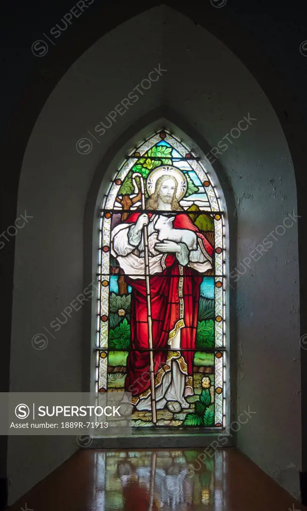 a stained glass window depicting jesus holding a sheep at church on the beach, ardnamurchan argyl scotland