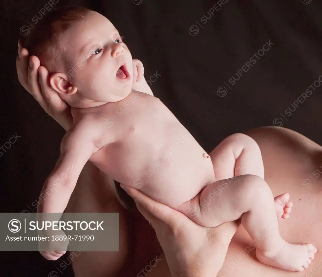 a father holding a bare baby, edmonton alberta canada