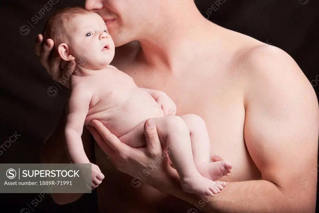 a father holding a bare baby, edmonton alberta canada