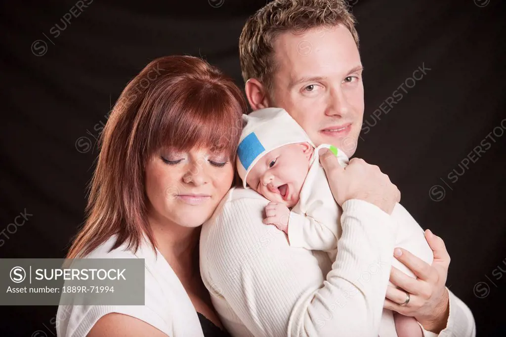 a mother and father hold a newborn baby, edmonton alberta canada