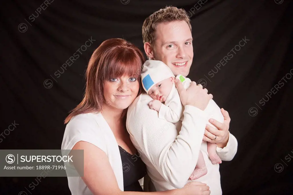 a mother and father hold a newborn baby, edmonton alberta canada