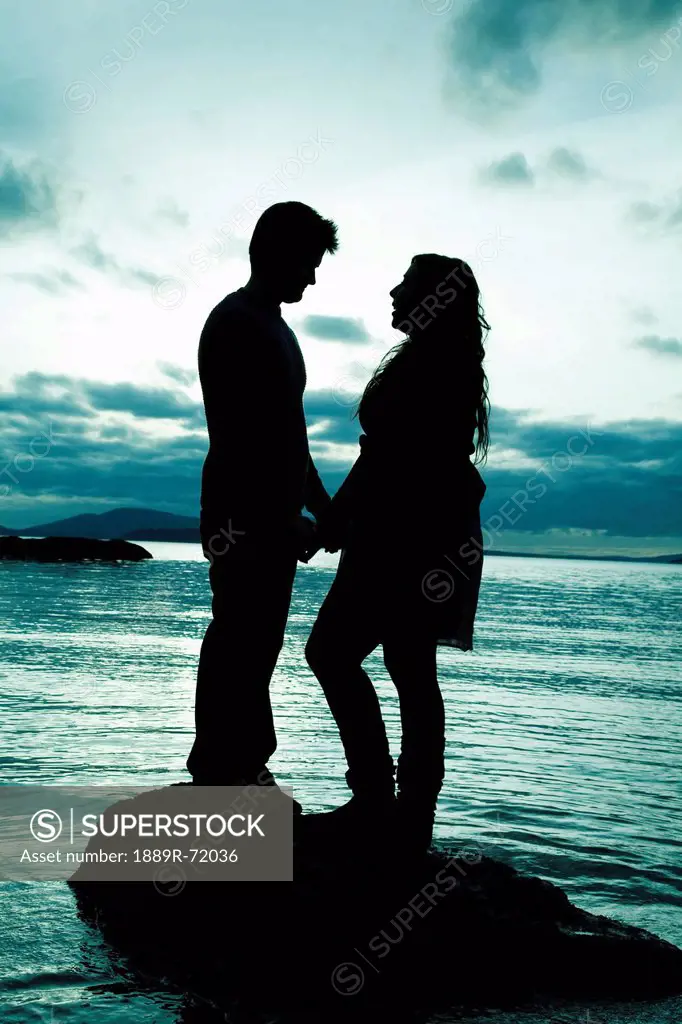 silhouette of a couple standing at the water´s edge, bellingham washington united states of america