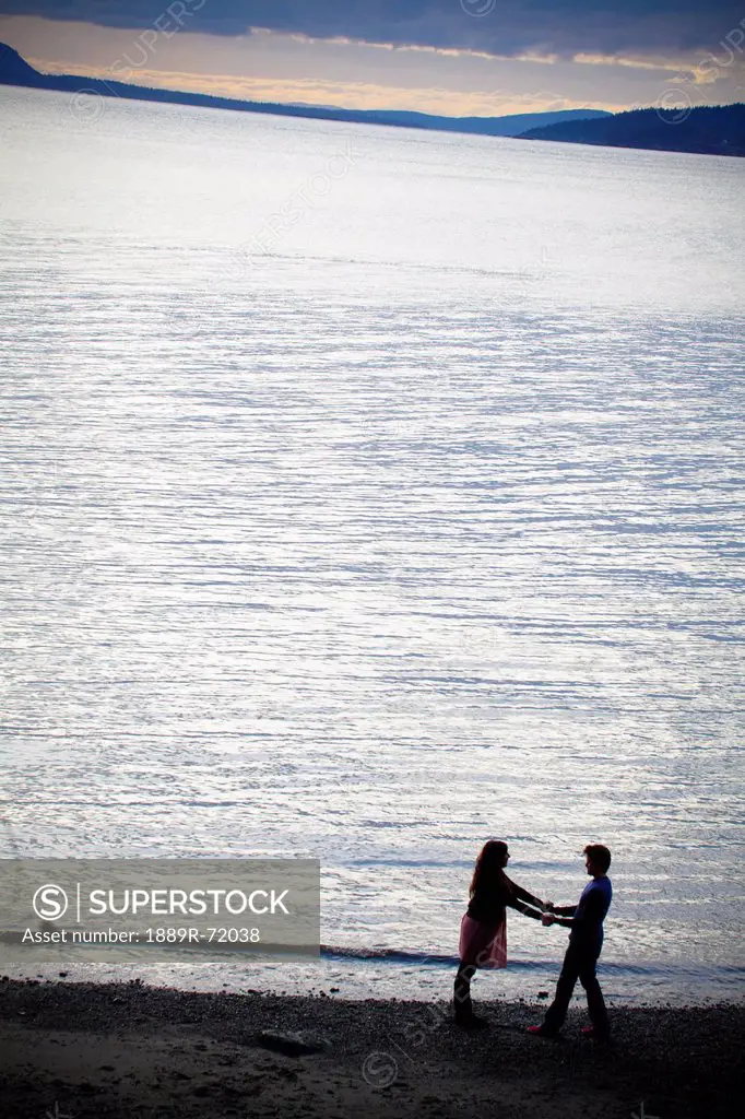 a couple on the beach on the water´s edge, bellingham washington united states of america