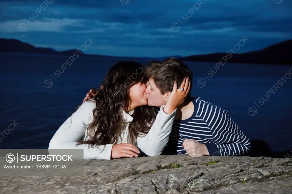 a young couple kissing on the shoreline at dusk, bellingham washington united states of america