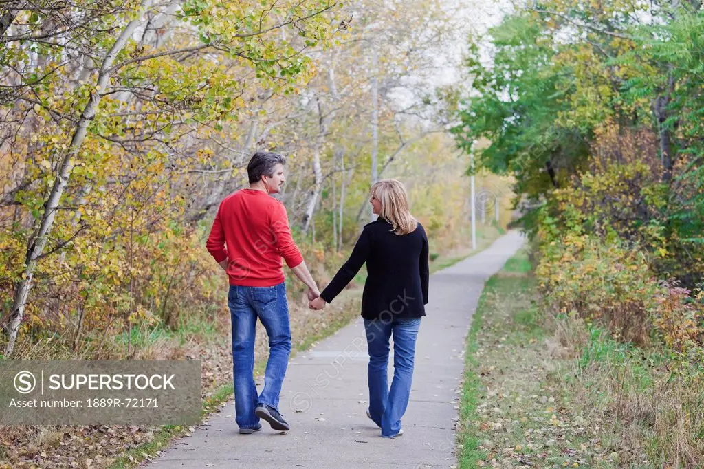 husband and wife walking in a park in autumn, st. albert alberta canada