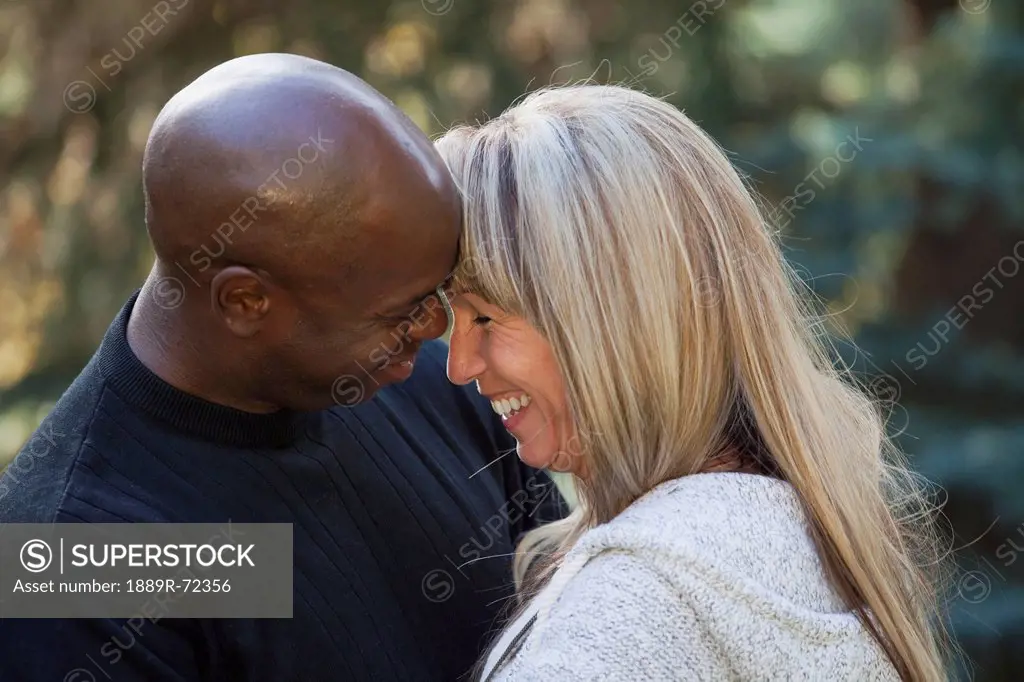 interracial couple laughing together in a park, edmonton alberta canada