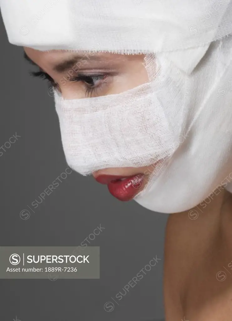 Woman with bandages on her face