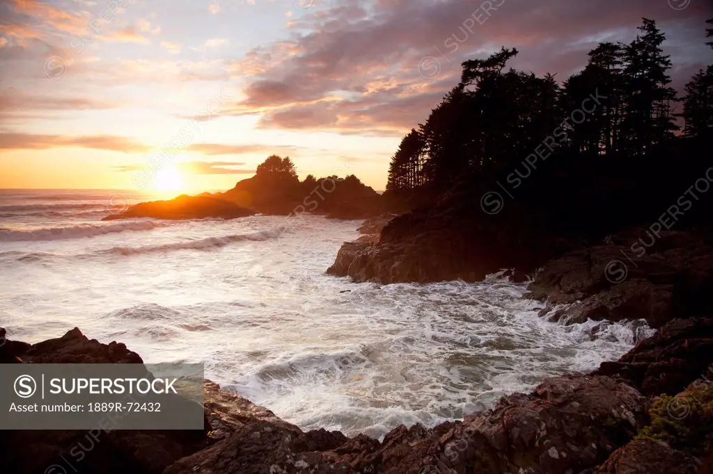 waves at cox bay and sunset point at sunset near tofino, british columbia canada