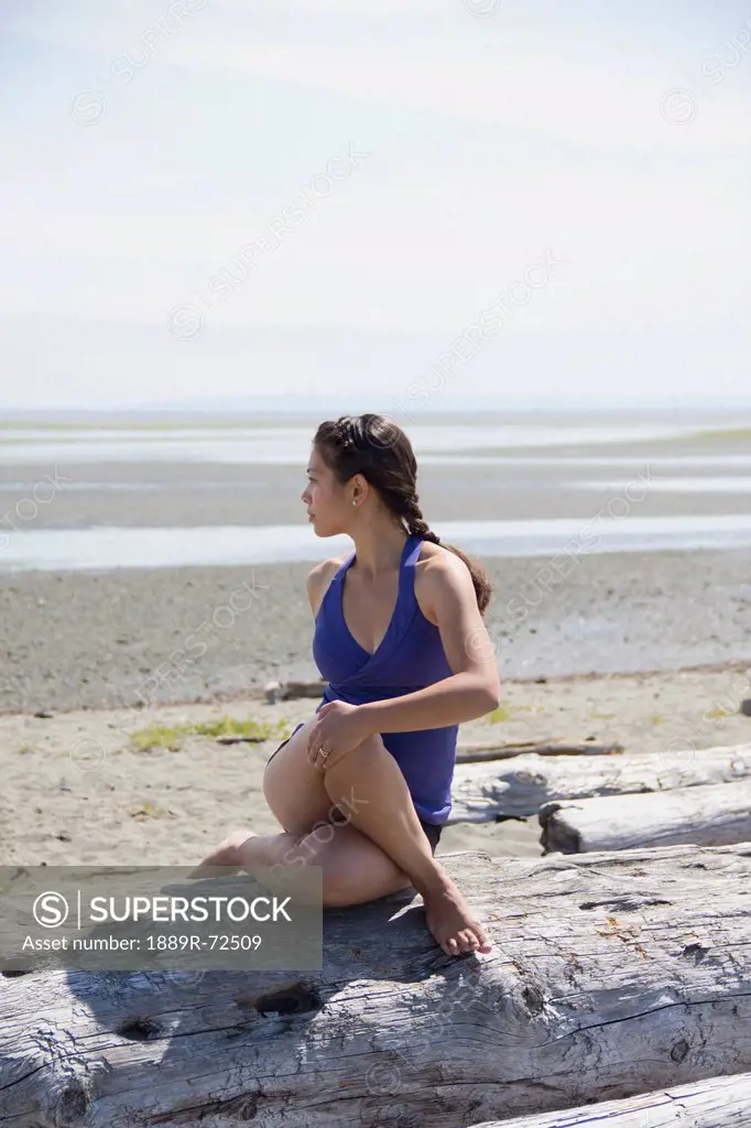 woman in exercise wear stretching on the beach, delta british columbia canada